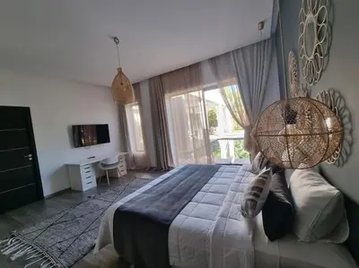 a bedroom with a large bed and a large window at Villa Le Clos de l'Atlas in Marrakech