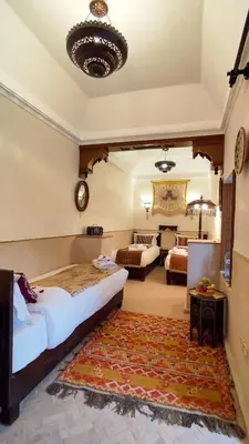 a bedroom with a bed and a living room at RIAD DAR En-Nawat in Marrakech