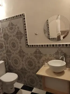 a bathroom with a toilet and a sink and a mirror at Riad l Ayinn in the heart of Marrakech. in Marrakech