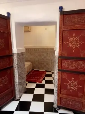a room with two beds and a checkered floor at Riad l Ayinn in the heart of Marrakech. in Marrakech