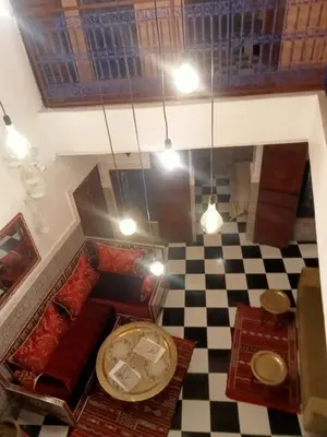 a room with a table and a checkered floor at Riad l Ayinn in the heart of Marrakech. in Marrakech