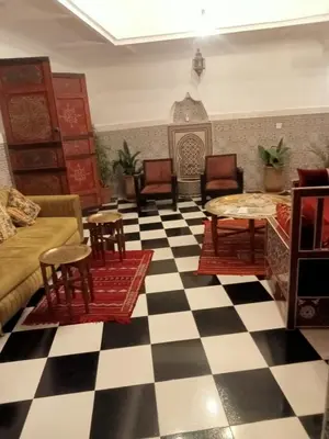 a living room with a black and white checkered floor at Riad l Ayinn in the heart of Marrakech. in Marrakech