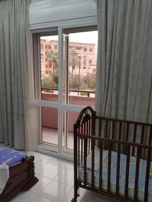a bedroom with a crib and a large window at Appartement warda in Marrakech