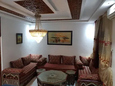 a living room with chairs and a chandelier at Appartement warda in Marrakech
