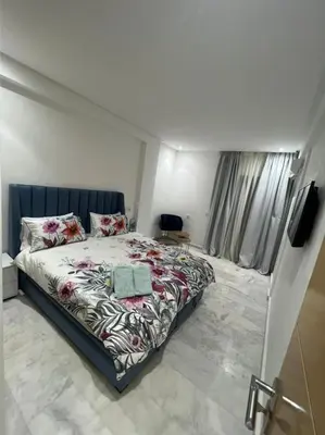a bedroom with a large bed and a television at PALACE B Av Hassan II Marrakech 40000-Specious UNIT#7 in Marrakech