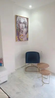 a chair and a table in a room with a painting at PALACE B Av Hassan II Marrakech 40000-Specious UNIT#7 in Marrakech