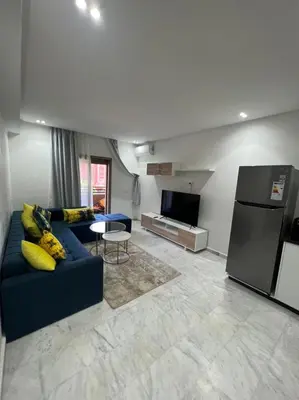 a living room with a blue couch and a refrigerator at PALACE B Av Hassan II Marrakech 40000-Specious UNIT#7 in Marrakech