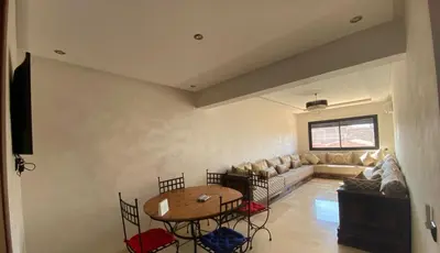 a living room with a table and a couch at Appartement cosy Gueliz avec piscine in Marrakech