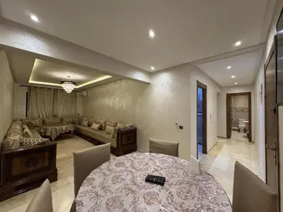 a living room with a table and a couch at Appartement cosy Gueliz avec piscine in Marrakech