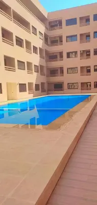a swimming pool in front of a building at Appartement cosy Gueliz avec piscine in Marrakech