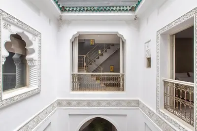 a hallway of a white building with a staircase at Riad Princesse Des Sables- Jaccuzzi& SPA-Breakfast in Marrakech
