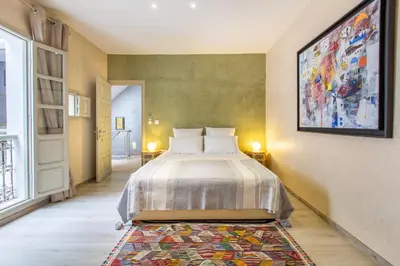 a bedroom with a bed and a painting on the wall at Riad Princesse Des Sables- Jaccuzzi& SPA-Breakfast in Marrakech
