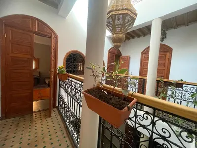 a balcony with a potted plant on a railing at Riad ouhmidi in Marrakech