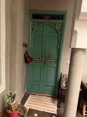 a green door in a room with a table at Riad Deux Palmiers in Marrakech