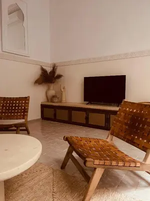 a living room with two chairs and a flat screen tv at Riad Nekhla in Marrakech