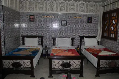 a room with two beds and a wall with patterns at Riad Marrakech Medina in Marrakech