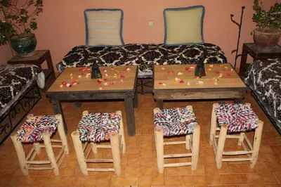 a living room with two tables and chairs and a couch at Riad Marrakech Medina in Marrakech
