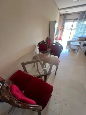 a living room with a glass table and chairs at Appartement Vue golf Marrakech in Marrakech