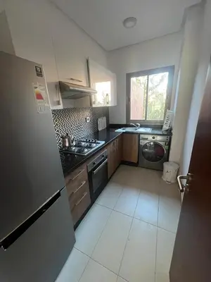 a kitchen with a refrigerator and a stove top oven at Appartement Vue golf Marrakech in Marrakech