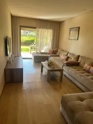 a living room with a couch and a table at Appartement Vue golf Marrakech in Marrakech