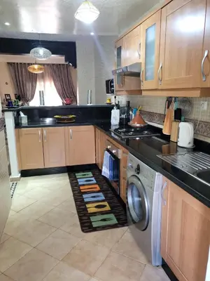 a kitchen with wooden cabinets and a washer and dryer at Atlas golf rossort in Marrakech