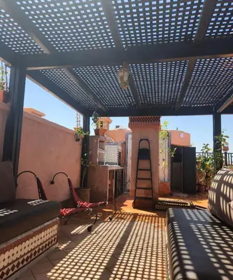 a pergola on a balcony with a table and chairs at Atlas golf rossort in Marrakech