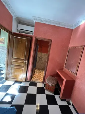 a room with a red wall and a door and a checkered floor at Riad Elijah Marrakech & SPA in Marrakech