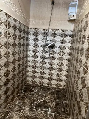 a bathroom with a shower with a tiled floor at Riad Elijah Marrakech & SPA in Marrakech