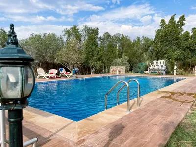 a swimming pool with a light pole next to it at Maison avec piscine et grand jardin 1 hectare in Marrakech