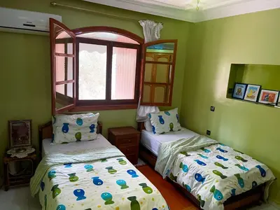 a bedroom with two beds and a window at Maison avec piscine et grand jardin 1 hectare in Marrakech
