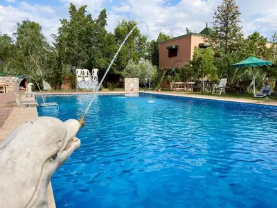 a person holding a fishing pole in front of a pool at Maison avec piscine et grand jardin 1 hectare in Marrakech