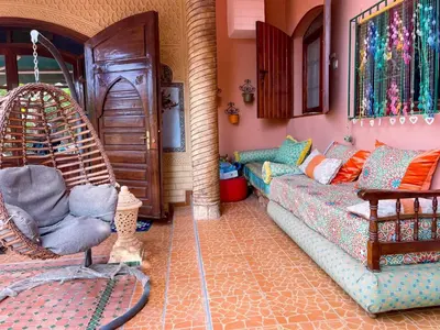 a living room with a couch and a swing at Maison avec piscine et grand jardin 1 hectare in Marrakech