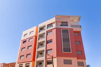 an orange and white building against a blue sky at ZARI Boutique ApartHotel in Marrakech
