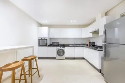 a kitchen with white cabinets and a washer and dryer at ZARI Boutique ApartHotel in Marrakech