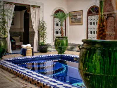 a swimming pool in a house with some vases at Riad Malida Marrakech in Marrakech