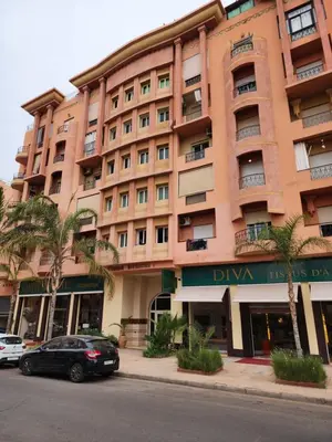 a large building with a car parked in front of it at Appartement en plein centre ville entièrement équipé in Marrakech