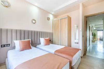 two beds in a room with white and orange pillows at New! Superbe appartement à Majorelle,terrace,IPTV. in Marrakech