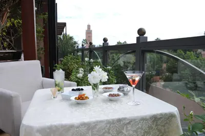 a white table with food and glasses on a balcony at Riad Wow in Marrakech