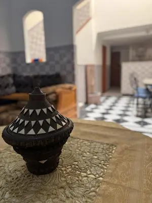 a black vase sitting on a table in a living room at Riad Naïel 3 piscines in Marrakech