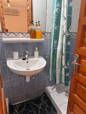 a bathroom with a sink and a shower curtain at Riad Naïel 3 piscines in Marrakech