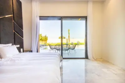 a bedroom with a bed and a view of a patio at Villa California, sans vis à vis, piscine Chauffée, Spa, in Marrakech