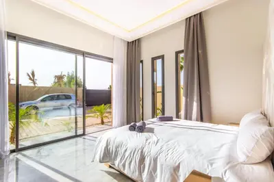 a bedroom with a bed and a large window at Villa California, sans vis à vis, piscine Chauffée, Spa, in Marrakech