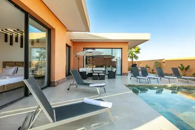 a villa with a swimming pool and a hotel at Villa Perle Rouge, Piscine , Cuisinière, Billard, playStation5 in Marrakech