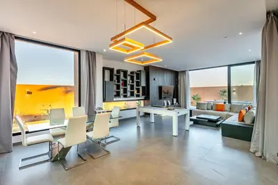 a living room with a couch and a table and chairs at Villa Perle Rouge, Piscine , Cuisinière, Billard, playStation5 in Marrakech