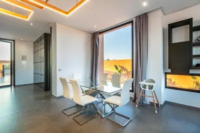 a dining room with a glass table and white chairs at Villa Perle Rouge, Piscine , Cuisinière, Billard, playStation5 in Marrakech