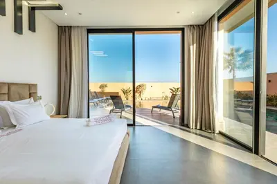 a bedroom with a bed and a view of the ocean at Villa Perle Rouge, Piscine , Cuisinière, Billard, playStation5 in Marrakech