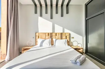 a bedroom with a large bed with two pillows at Villa Perle Rouge, Piscine , Cuisinière, Billard, playStation5 in Marrakech