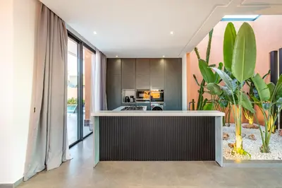 an open kitchen with plants in a house at Villa Perle Rouge, Piscine , Cuisinière, Billard, playStation5 in Marrakech