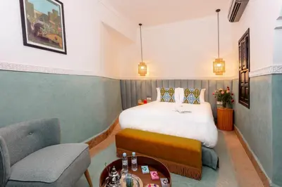 a bedroom with a bed and a chair and a table at Riad JW, La Medina autrement in Marrakech