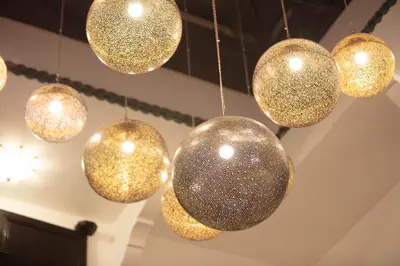 a bunch of gold lights hanging from a ceiling at Riad JW, La Medina autrement in Marrakech